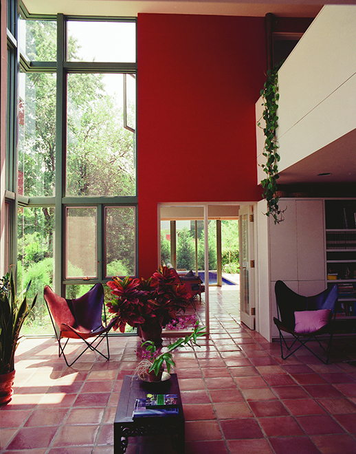 Image of living space with chairs, tall windows, natural light, and color