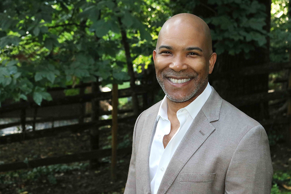 man smiling and looking at the camera while outdoors