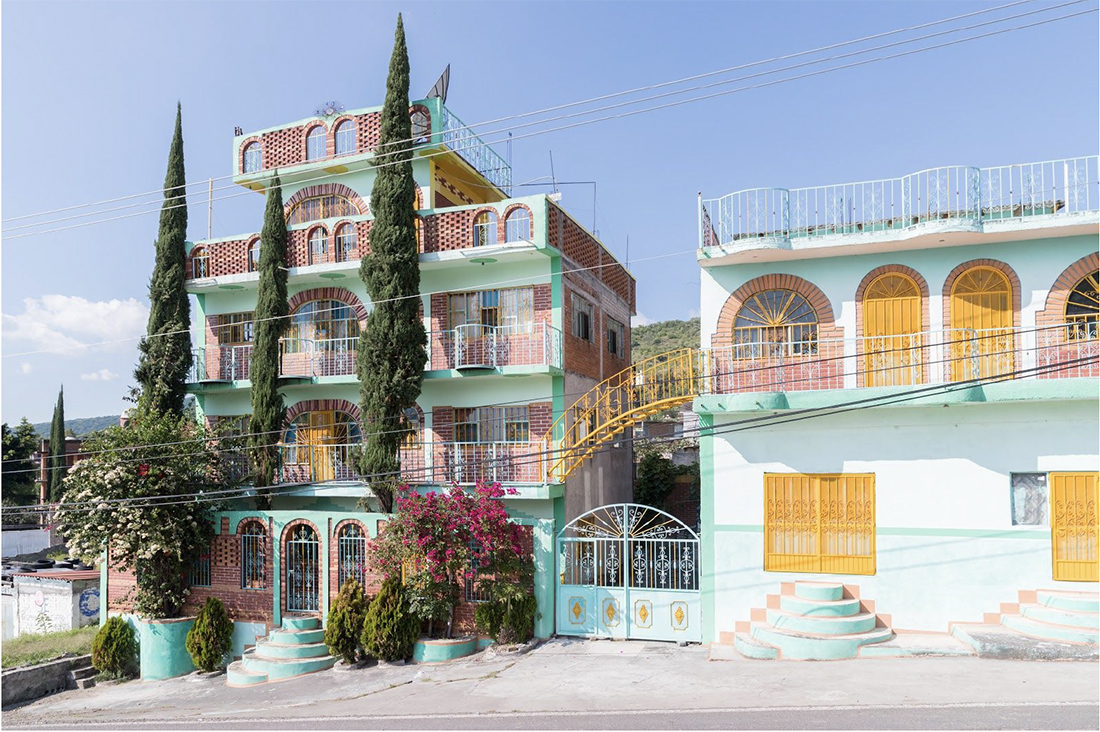 Tiered brick homes trimmed in mint facades with yellow accents and green shrubbery