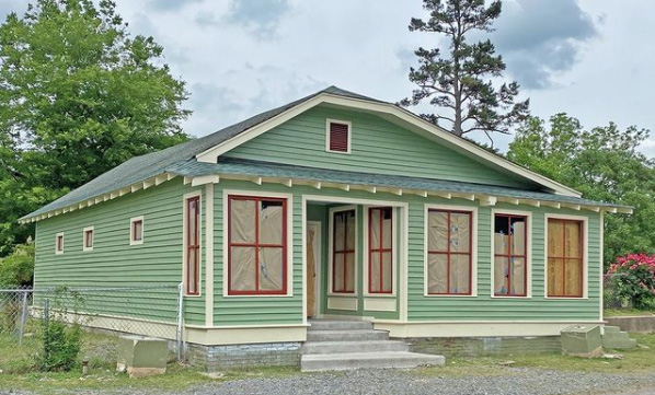 Green house with red trimmed windows