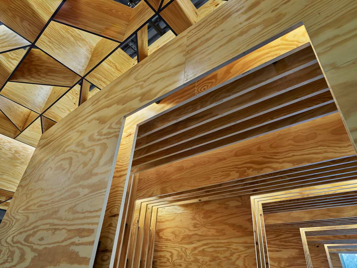 interior photo shot from below, looking up at geographic wood ceiling and layered cutout wood panels for the walls.  